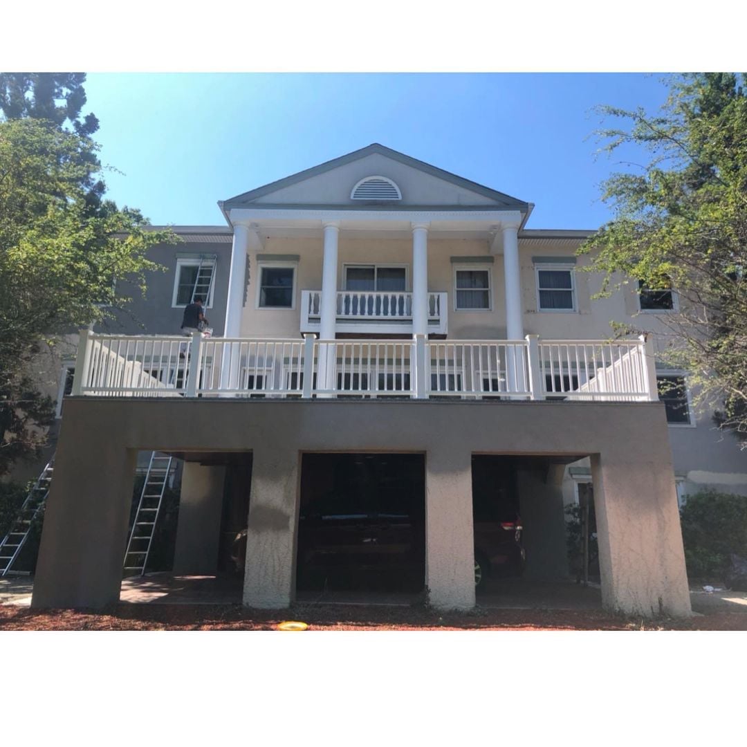 Boonton NJ 3 Colonial-style home mid-renovation with light beige stucco and white trim; ladders and painter visible on site