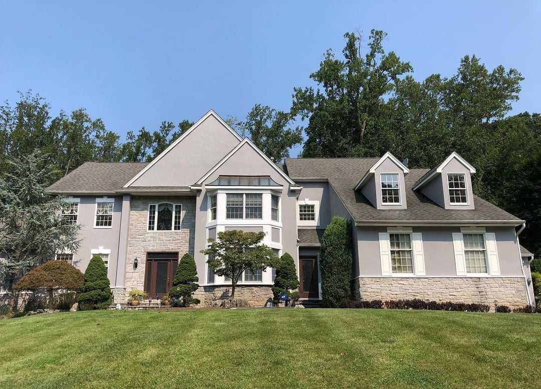 Morganwille NJ 4 Elegant front view of a fully restored stucco home in Morganville New Jersey with smooth siding and fresh paint