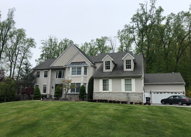 Morganwille NJ 3 Front view of a large home in Morganville NJ with visible stucco discoloration and signs of moisture infiltration