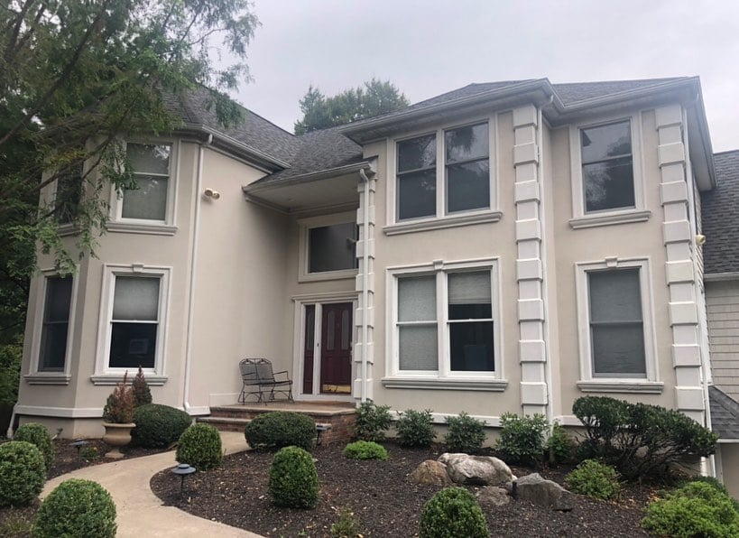 Stucco Paint 3 Front view of a home in Morganville NJ with beige stucco walls and red door before professional painting update